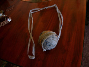 a roll of yarn made from gray plastic shopping bags