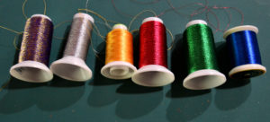 Different kinds of metallic threads in primary colors