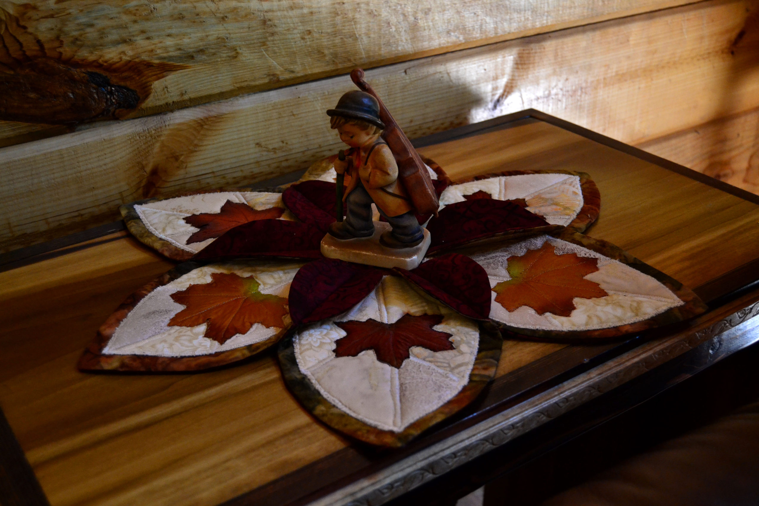 A little fiddler boy in the middle of a elegant autumn leaf candle holder