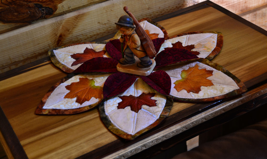 A little fiddler boy in the middle of a elegant autumn leaf candle holder