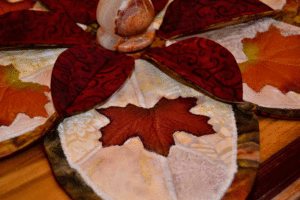Burgundy red maple leaf on a multi-cream background in our elegant autumn leaf candle holder