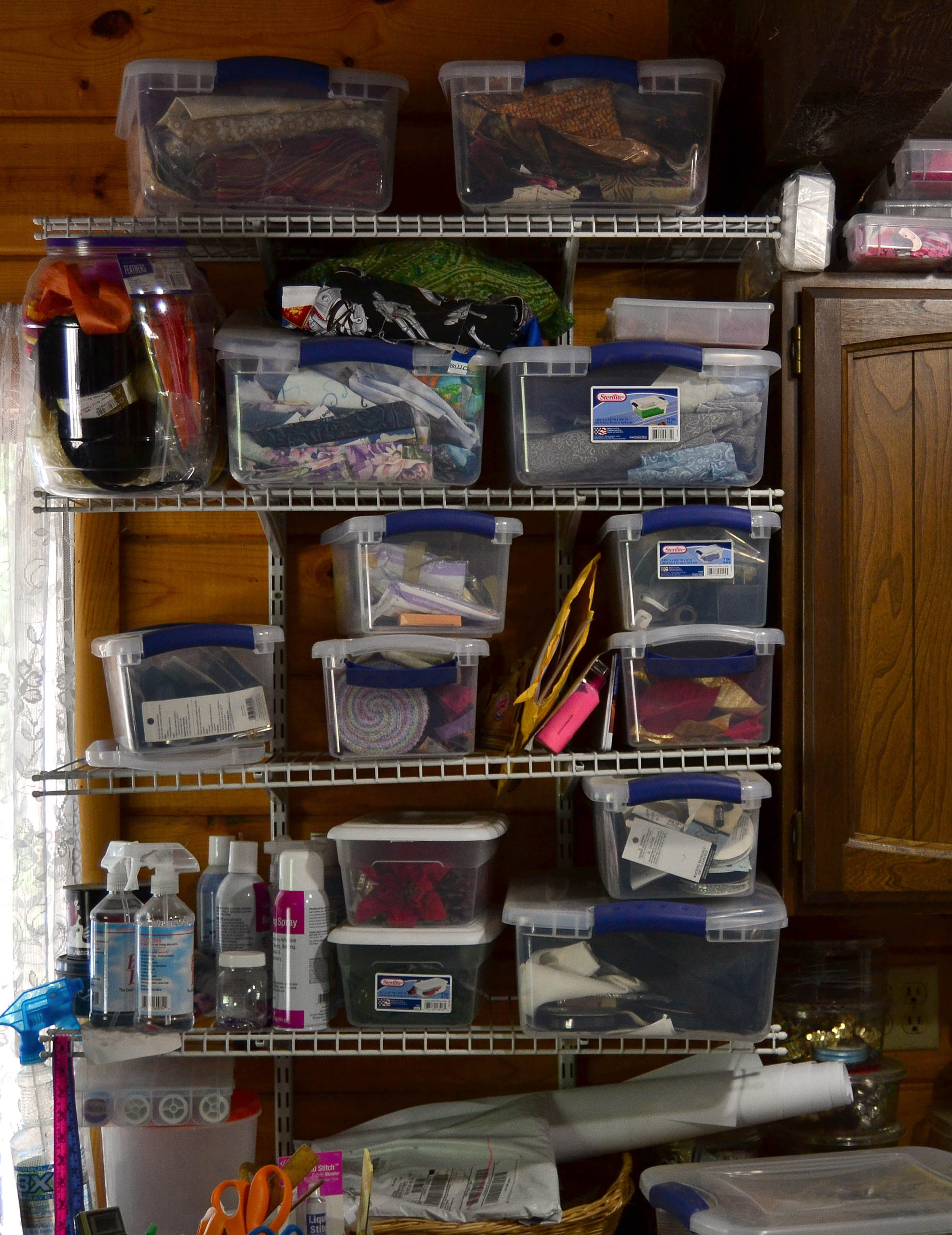 Wire shelves to hold sewing supplies, all the clutter corralled in tubs