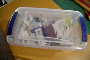 Plastic tub filled with sewing supplies used for corralling clutter