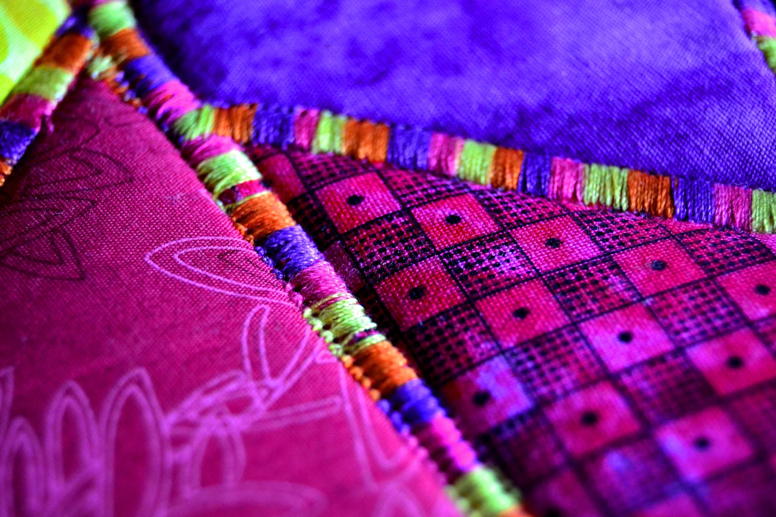 Variegated Thread on a purple and pink fabric art quilt