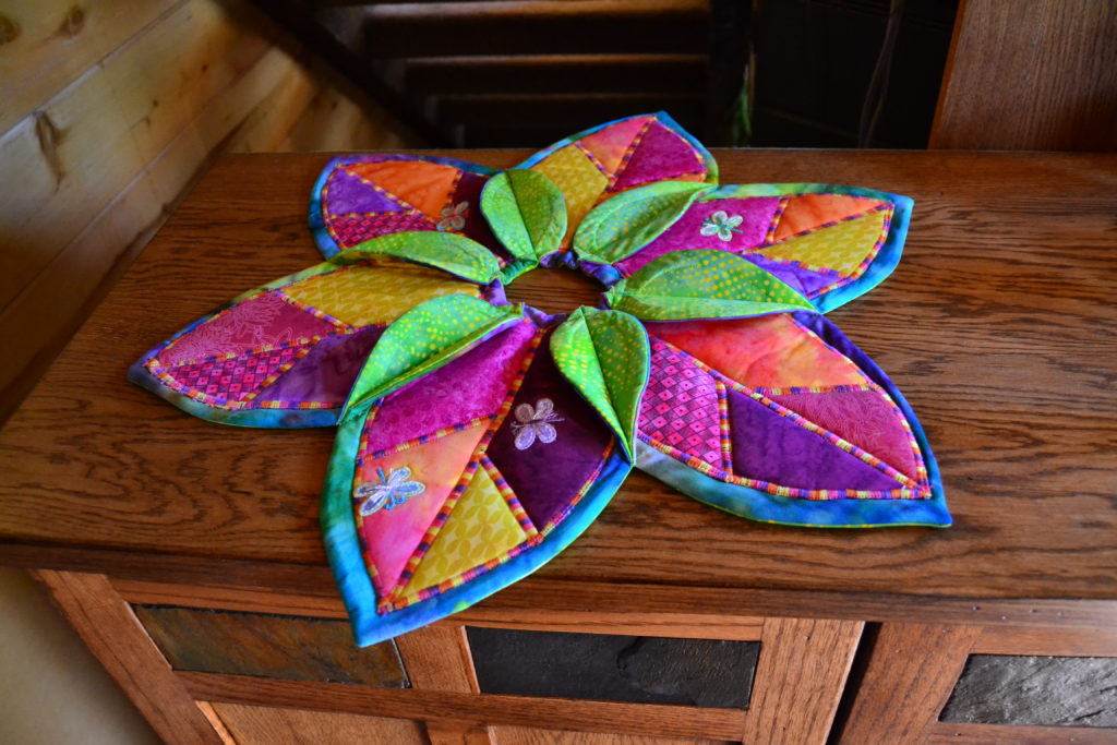 Brilliantly colored summer lily pad table topper/candle holder is a great example of how quilting foam can make quilts burst and pop with effect