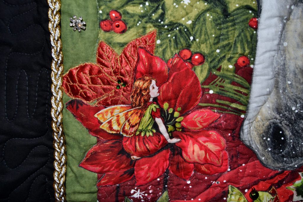 Christmas Delivery - Christmas small wall hanging, what a completed project of a fabric panel for quilting looks like - close-up of an added fairy on a new poinsettia flower
