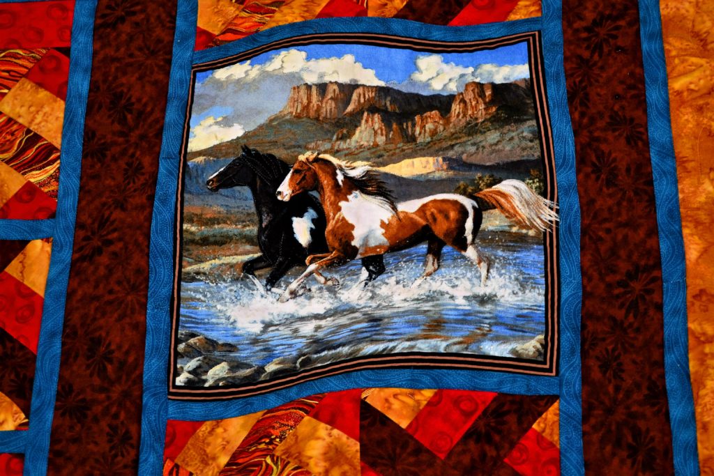 Home Pastures - a project that used printed fabric panels for quilting - close-up of horses running through a stream