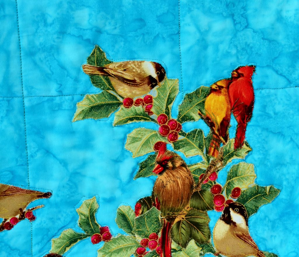 Small birds appliqued on a blue sky background - paperbacked fusible webbing used for sewing appliques on quilts