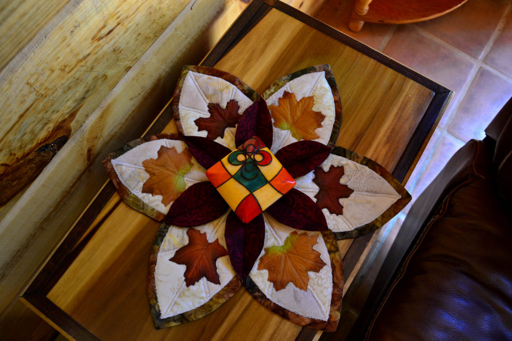 Autumn leaf round table topper with cream in the background as part of the landscape quilt design