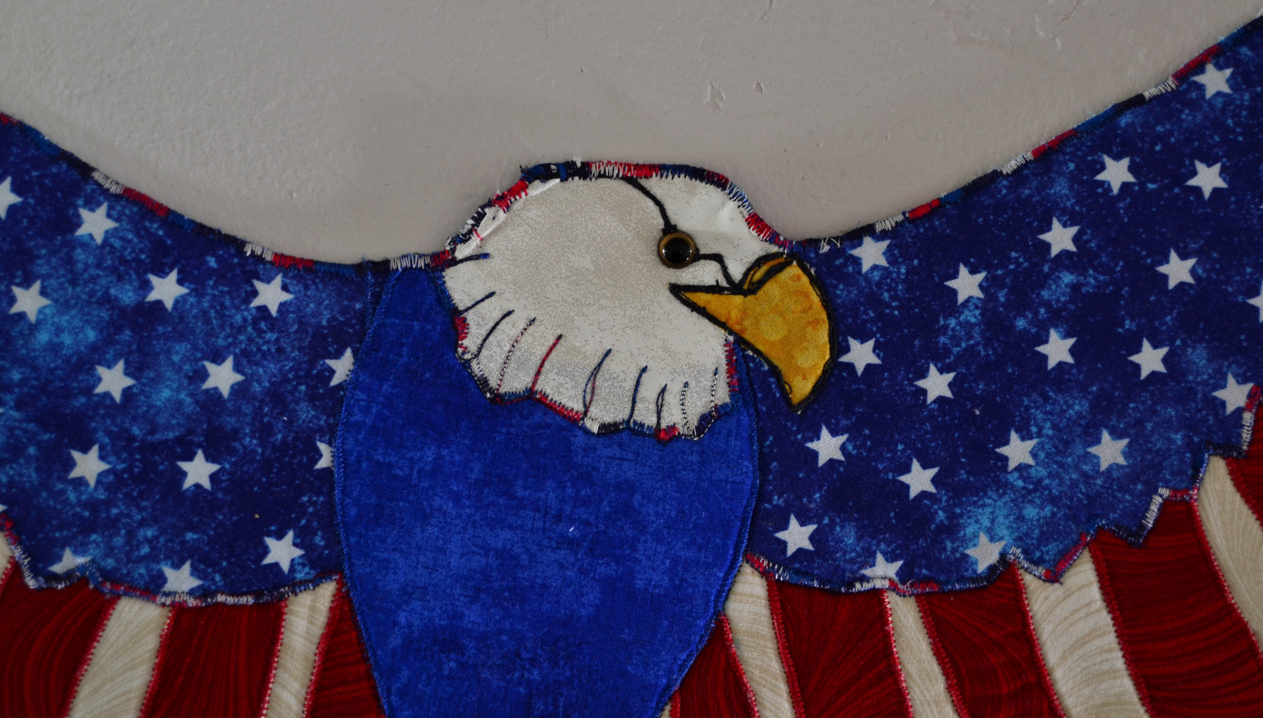 American bald eagle flies wings spread with the colors of the flag, red, white and blue