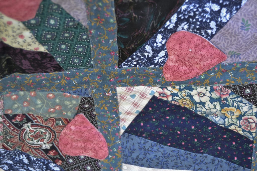 blue and rose quilt squares joined with sashing and hearts