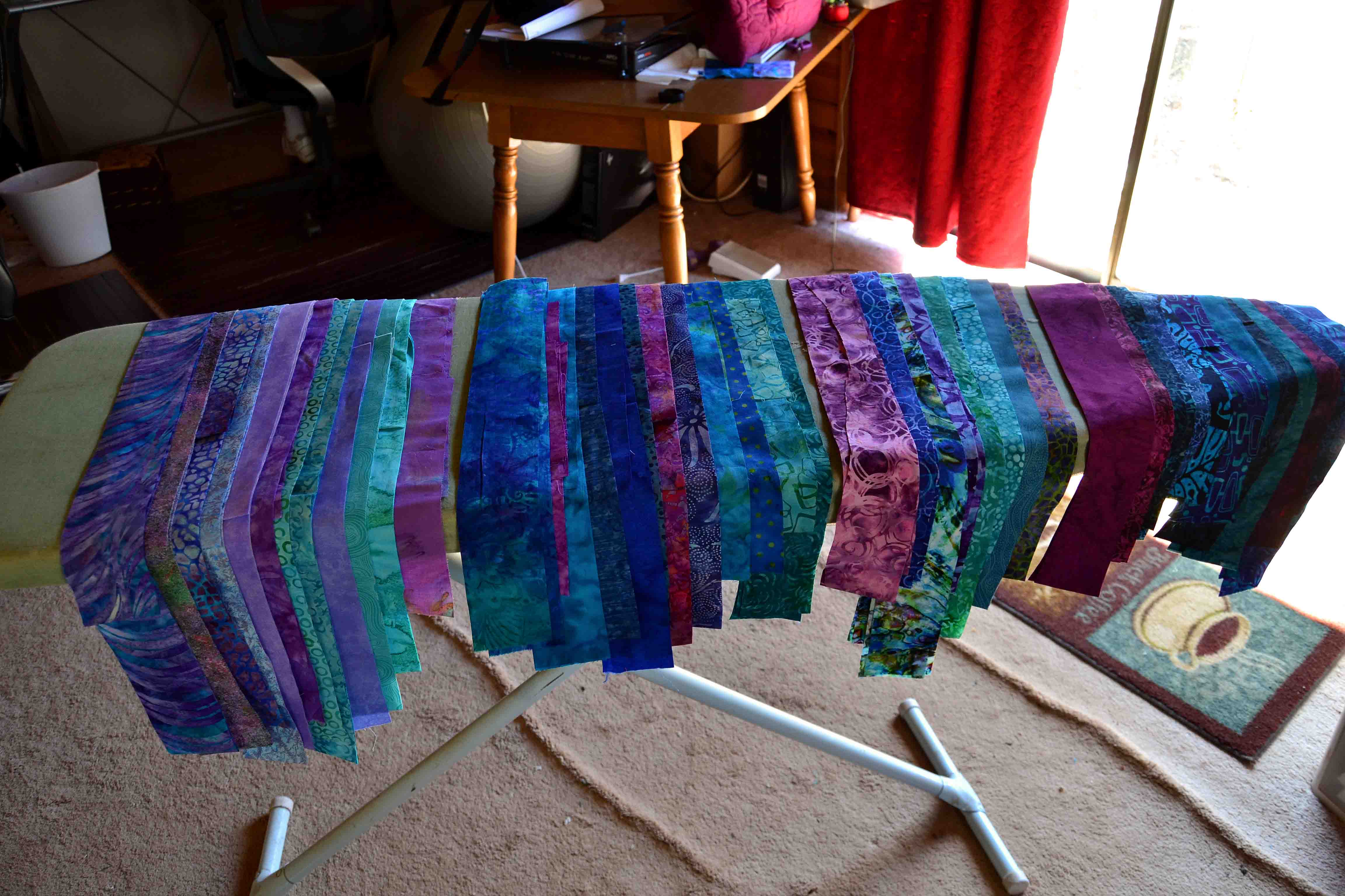 Show strips of fabric laid out over an ironing board