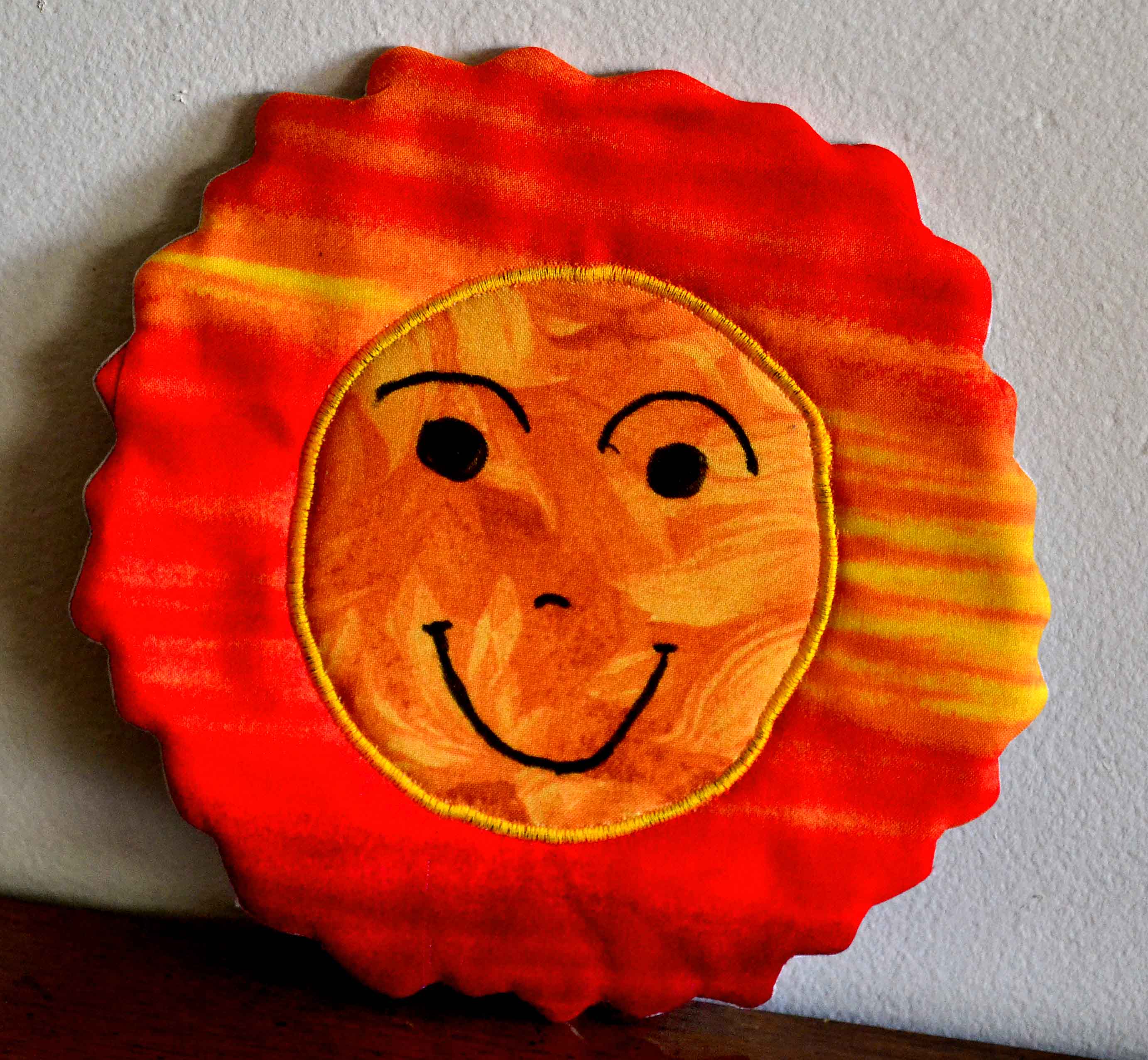 Fabric sun with a smiling face shaped potholder