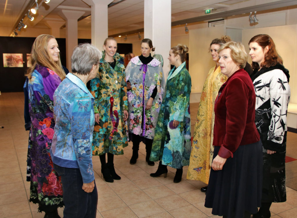 Marijke and friends wearing jackets of wearable art