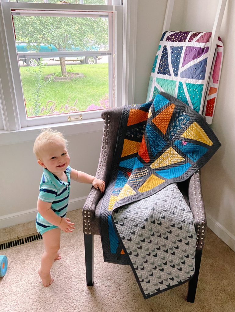 Color Jolt quilt geometric quilt designs with little boy holding it